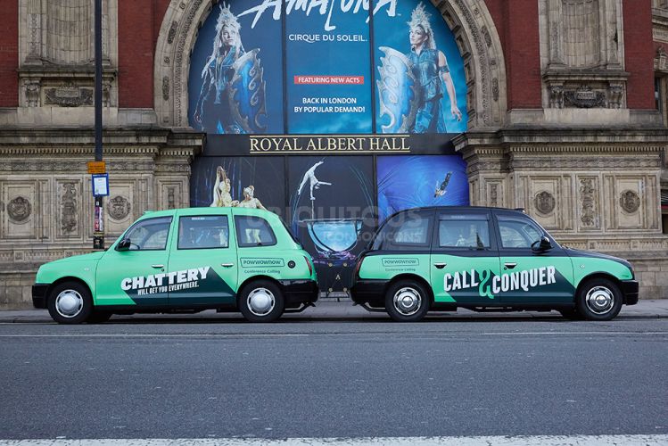 Two taxis with advertisements
